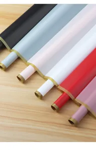 Detail view of colorful matte waterproof flower wrapping paper rolls with elegant gold border.
