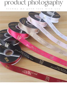 Detailed view of foil-stamped love polyester ribbon rolls for flower bouquet and gift wrapping.