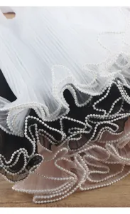 Vue detaillee de tulle plisse multicouche avec bordure de perles pour emballage floral.