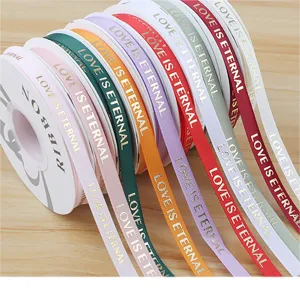 Close up detail of colorful grosgrain ribbons with gold stamped love text for wrapping.