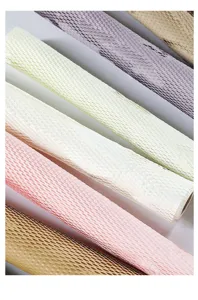 Vue de détail de rouleaux de papier d'emballage floral en nid d'abeille colorés et élégants.