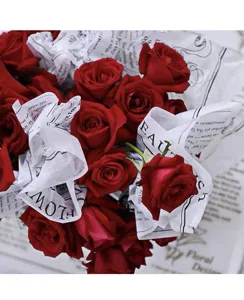 Bouquet de roses rouges enveloppé dans du papier de soie vintage anglais pour arrangements.