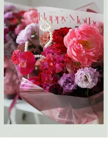 Detailed shot of pink cellophane flower wrapping paper, colorful bouquet arrangement with card.