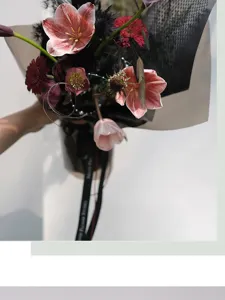 Detailed view of a beautiful mixed flower bouquet with elegant wrapping paper and ribbon.