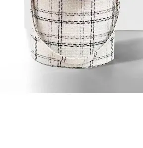 Dettaglio della struttura in tessuto tweed in bianco e nero della scatola per fiori con manico.