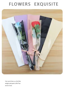 Gros plan détaillé de sacs d'emballage de roses colorés et de matériaux floraux sur du bois.
