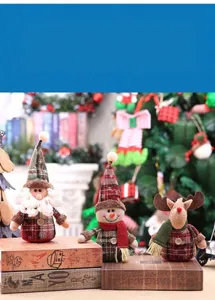 Macro shot of festive Christmas gnome and reindeer dolls standing on vintage books by a tree.