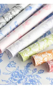 Vue rapprochée détaillée de rouleaux de papier de soie à motifs floraux pour bouquets.