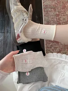 Vue détaillée de chaussettes mi-hautes en filet pour femmes avec broderie nœud.