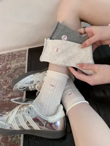 Chaussettes mi-mollet en résille brodées d'un nœud mignon, vue de détail motif losanges.