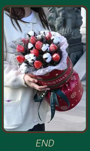 Detailansicht der handgefertigten Weihnachts-Erdbeer- und Baumwoll-Blumenstrauß-Geschenkbox.