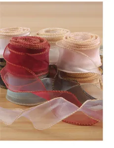 Rotolo di nastro in organza trasparente con bordo dorato per confezioni floreali e decorazione.