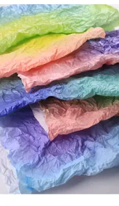 Close up view of colorful gradient floral tissue paper showing crumpled texture and stacked detail.