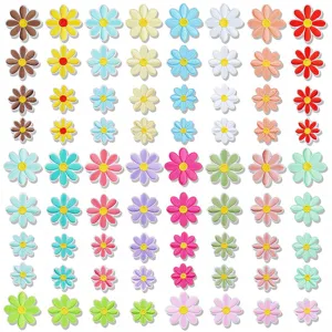 Close-up detail of colorful embroidered daisy flower patches in various sizes for clothing decor.