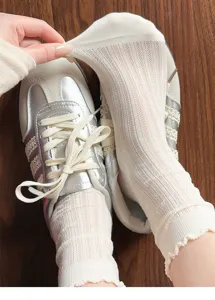 Detailed close-up of white mesh frilly cotton socks showing breathable texture and stretch.