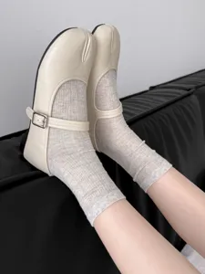Ballet style split toe mary jane shoes with ribbed crew socks in chic neutral tones.