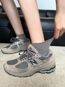 Grey casual sneakers paired with cozy mid-calf cotton socks for stylish everyday wear.