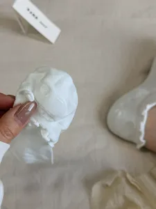 Vista dettagliata di calzini bianchi con volant e silicone antiscivolo sul tallone per comfort.