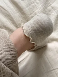 Primo piano di comode calze fantasmino in cotone con delicato bordo in pizzo arricciato e morbido.