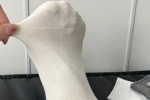 Close-up detail of women's white ribbed short socks, showing soft cotton stretchable fabric.