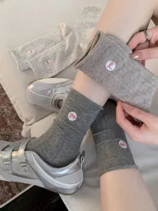 Chaussettes mi-hautes japonaises mignonnes pour femmes avec broderie nœud rose et design en maille.