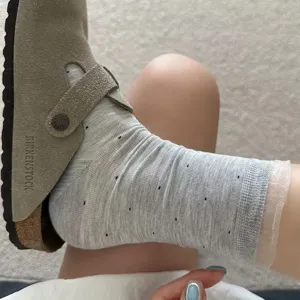 Chaussettes mi-hautes grises pour femmes à pois et dentelle organza, modèle modal d'été léger.