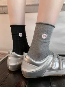 Gros plan de chaussettes pour femmes avec broderie nœud et design en maille respirante.