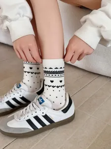 Close-up detail of vintage Fair Isle heart pattern mid-tube cotton socks worn on feet.