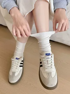 Detail shot of white cotton crew socks with elastic ribbed cuff for women, daily wear.