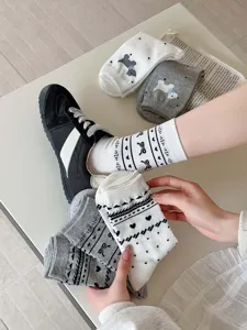 Close-up detail of Korean style vintage mid-calf cotton socks with cute puppy and bow patterns.