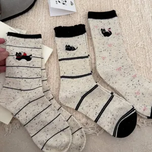 Women's mid-calf socks feature cute cat embroidery, black cuffs, and speckled yarn style.