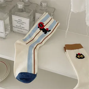 Cute black cat embroidered mid-calf socks detail shot, showcasing soft fabric and striped design.