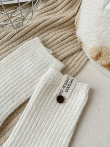 Detail van wollen mix middensokken, gezellige geribbelde breistructuur met knoop en stoffen label.