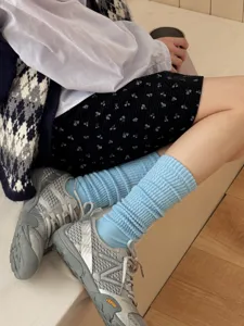 Primo piano di calze lunghe e morbide abbinate a scarpe sportive per outfit autunnali.
