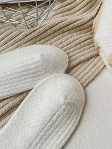 Close-up van witte gebreide wollen sokken, gestructureerd winterwarm sokdetail shot.
