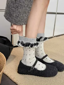 Vue détaillée de chaussettes mi-hautes vintage à pois avec volants à carreaux mignons.