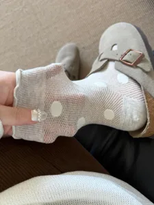Close-up detail of sheer white polka dot socks with breathable mesh texture and cute lace cuff.