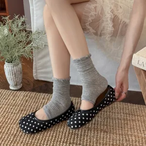 Gedetailleerd overzicht van grijze stijgbeugelsokken, schattige beenwarmers en stippen ballerina's.