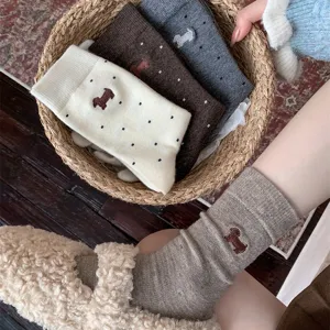 Detailed shot of cute dachshund embroidered polka dot wool mid-tube socks in a basket.