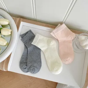 Comfortable women's ribbed mid-tube socks in grey, white, and pink, detail view.