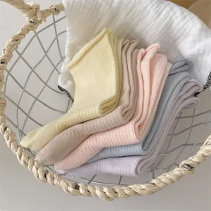 Close-up detail of soft pastel ribbed crew socks neatly stacked in a wire basket.
