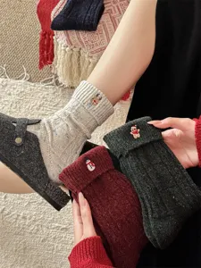 Detailed view of cozy winter wool Christmas socks featuring cute embroidered holiday character designs.