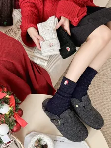 Close-up detail of cozy wool winter socks with cute Christmas embroidery and warm plush lining.