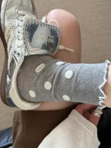 Stylish grey mid-tube socks featuring cute white polka dots and delicate ruffle lace edges.