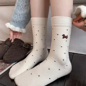 Close-up detail of women's warm cashmere mid-tube socks featuring cute dachshund puppy embroidery.