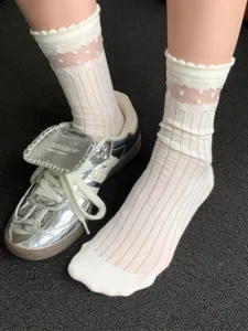 Detail view of sheer white lace mid-tube socks with polka dot pattern and breathable mesh.