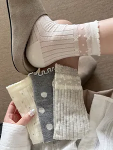 Close-up detail of sheer women's mid-tube socks featuring mesh design, lace edge and cute polka dots.