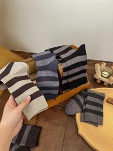 Détail de chaussettes mi-mollet en cachemire rayées, texture tricot douce pour automne hiver.