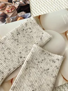 Detailed view of cream speckled wool blend knit socks texture, cozy winter lifestyle accessory.