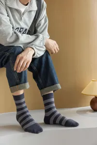 Gros plan détaillé de chaussettes rayées douillettes en molleton gris et gris foncé.